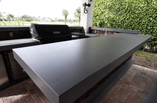 This extended outdoor space makes the outside area more usable features artistic concrete counter top