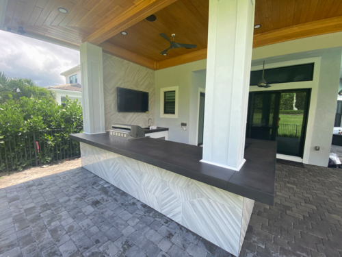 Outdoor kitchen with artistic concrete countertops with built-in ice bucket and cypress ceilings