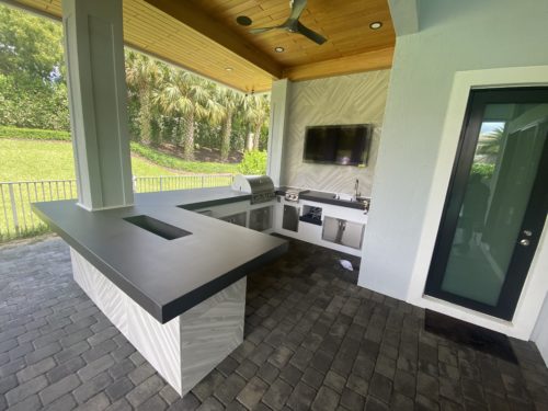 Outdoor kitchen with artistic concrete countertops with built-in ice bucket